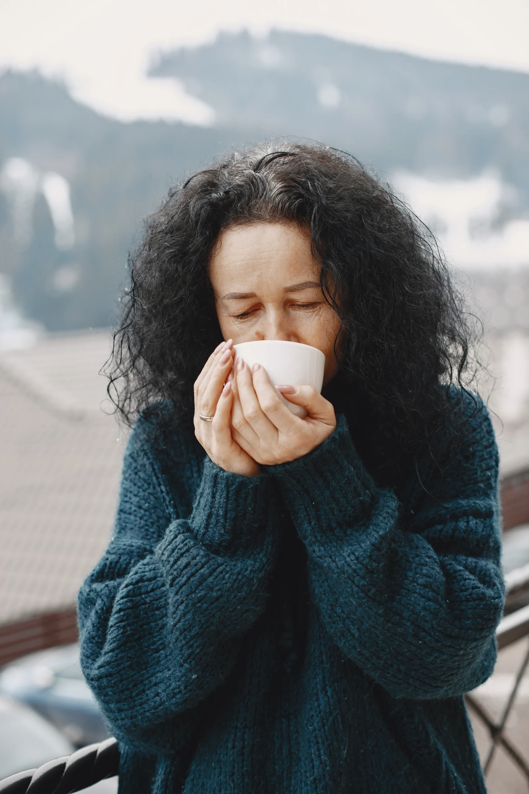 Woman with a cold holding a warm cup of tea